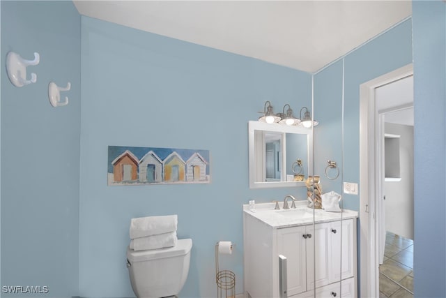 bathroom with tile patterned flooring, vanity, and toilet