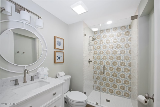 bathroom featuring tiled shower, vanity, and toilet