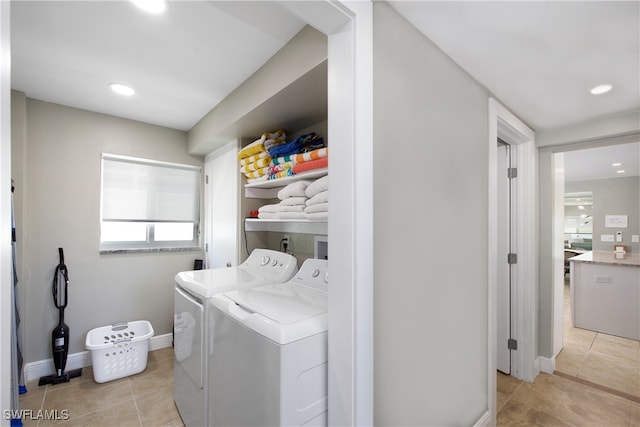 laundry room with washer and clothes dryer and light tile patterned floors