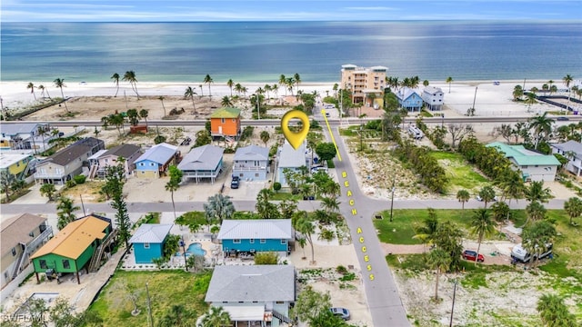 birds eye view of property with a water view and a beach view