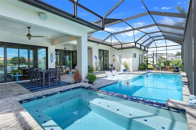 view of pool featuring a lanai, a patio area, ceiling fan, and a pool with connected hot tub