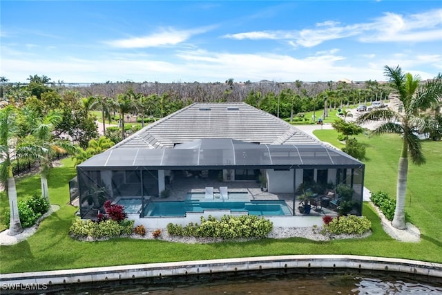 back of house with an outdoor pool, glass enclosure, a water view, a yard, and a patio area