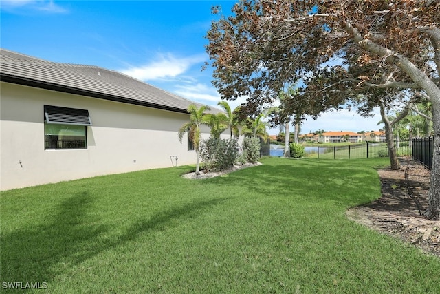 view of yard featuring a water view and fence