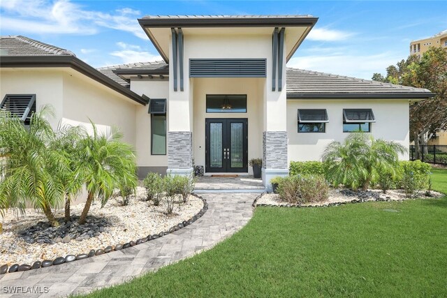 property entrance featuring a yard and french doors