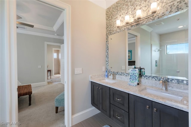 bathroom featuring visible vents, a sink, a tile shower, and baseboards