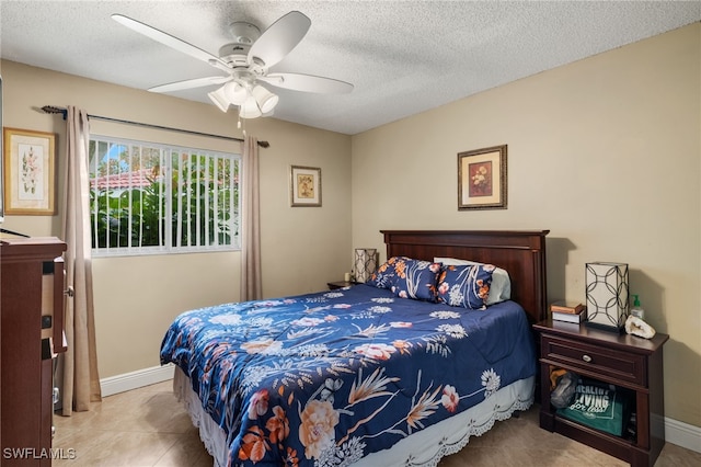 tiled bedroom with ceiling fan and a textured ceiling