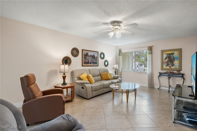 living room featuring a textured ceiling, light tile patterned floors, and ceiling fan