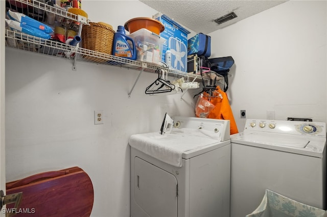 washroom featuring a textured ceiling and separate washer and dryer