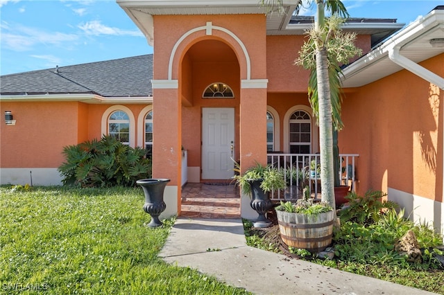 view of exterior entry featuring a yard