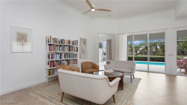 living area featuring a towering ceiling, ceiling fan, ornamental molding, and light tile patterned flooring