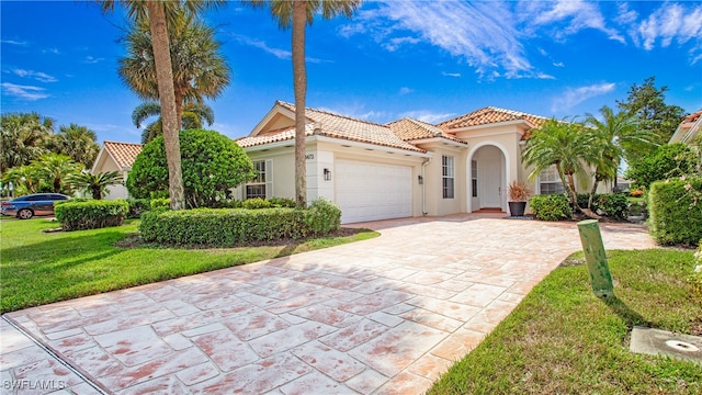 mediterranean / spanish house with a front lawn and a garage