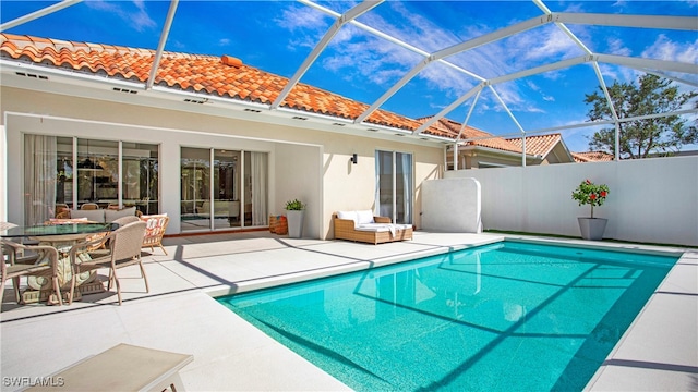 view of pool with a patio and glass enclosure