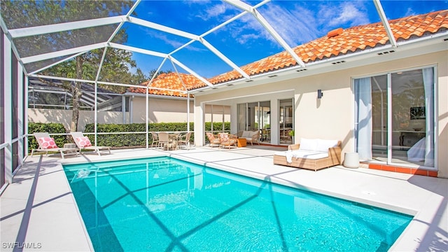 view of pool with a patio and glass enclosure