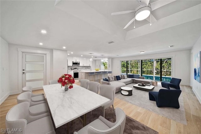 dining space with light hardwood / wood-style flooring and ceiling fan