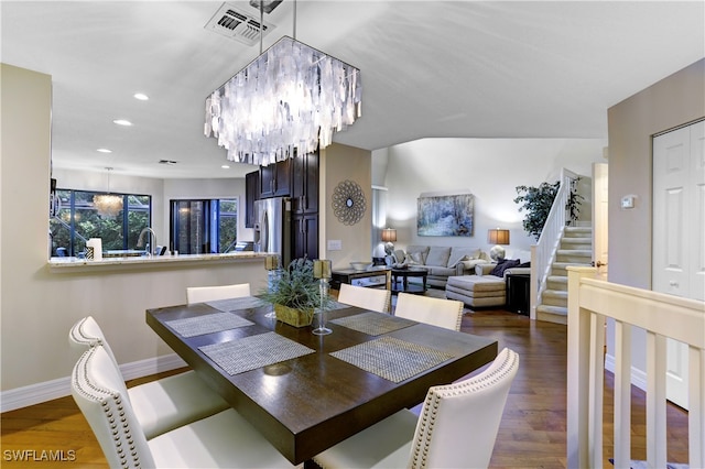 dining area with dark wood-type flooring and a notable chandelier