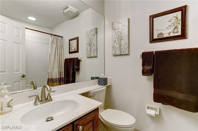 bathroom with curtained shower, vanity, and toilet