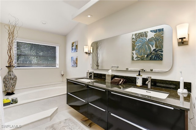 bathroom featuring tile patterned flooring, lofted ceiling, a tub to relax in, and vanity