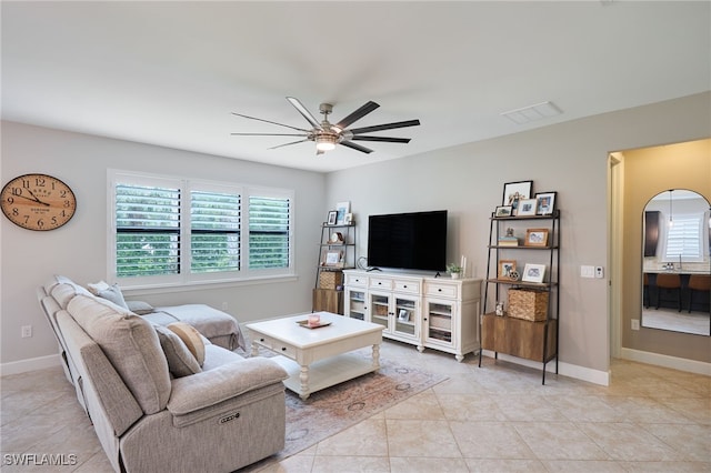 tiled living room with ceiling fan