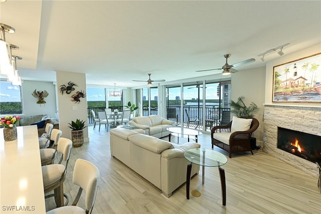 25875 Hickory Blvd Unit 502, Bonita Springs, FL 34134 - living area with light wood-style flooring, ceiling fan, and a fireplace