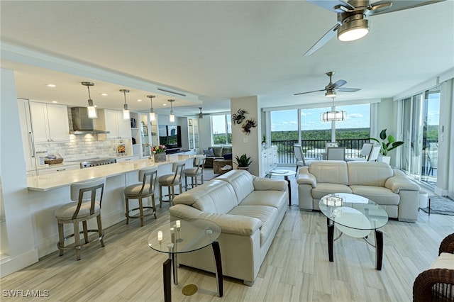 living room with ceiling fan and light hardwood / wood-style flooring