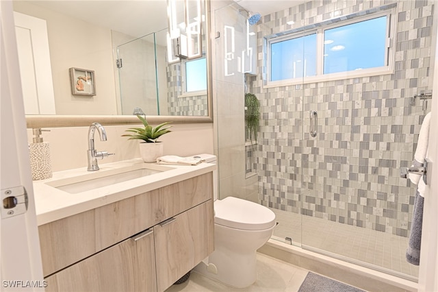 bathroom featuring tile patterned floors, a shower with shower door, vanity, and toilet