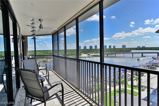 unfurnished sunroom featuring a water view and ceiling fan