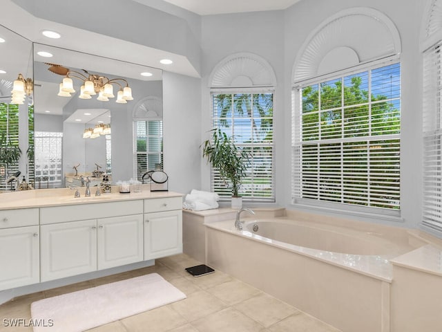 bathroom featuring a notable chandelier, vanity, a bathing tub, and tile patterned flooring