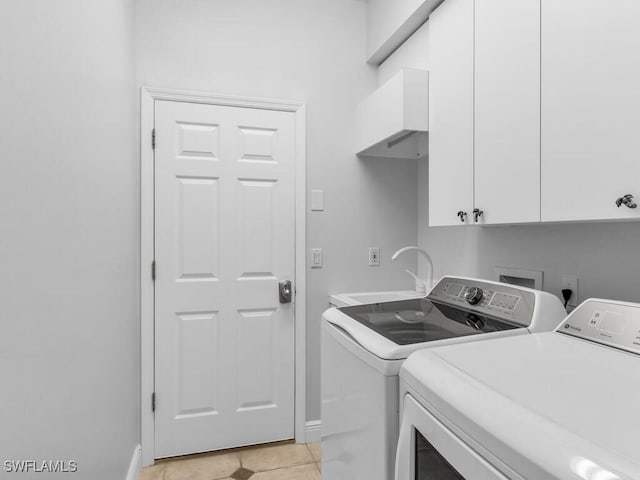 laundry room featuring washing machine and dryer, light tile patterned flooring, sink, and cabinets