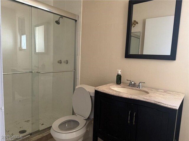 bathroom with walk in shower, vanity, and toilet