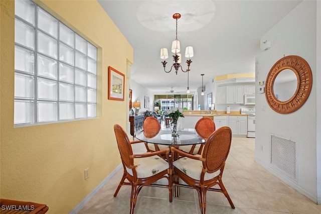 dining area with light tile patterned flooring and ceiling fan with notable chandelier