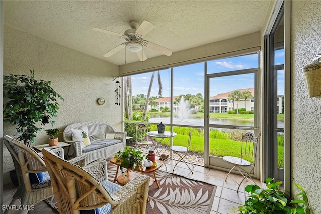 sunroom / solarium with a water view and ceiling fan