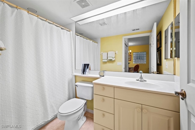 bathroom with toilet, vanity, and tile patterned flooring