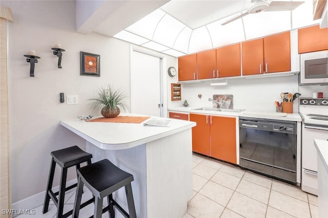 kitchen featuring white appliances, kitchen peninsula, light tile patterned floors, a kitchen bar, and sink