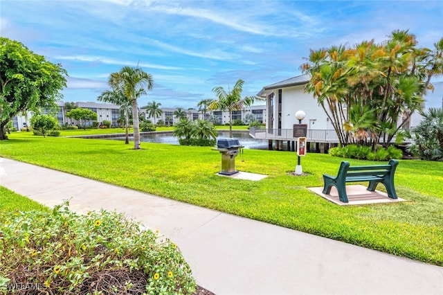 view of community with a lawn and a water view