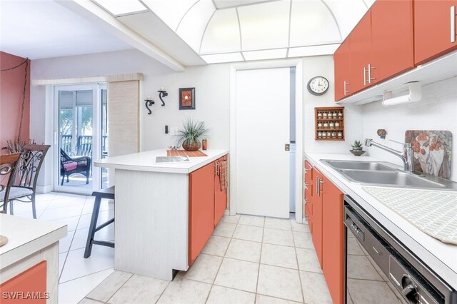 kitchen with black dishwasher, sink, light tile patterned floors, and a kitchen bar