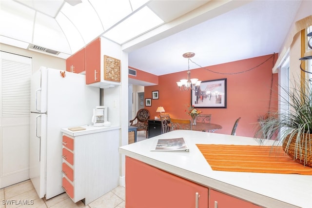 kitchen featuring white refrigerator, an inviting chandelier, hanging light fixtures, and light tile patterned floors