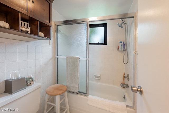 bathroom with shower / bath combination with glass door, tasteful backsplash, and toilet