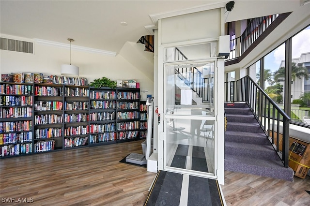 stairway featuring hardwood / wood-style flooring and crown molding