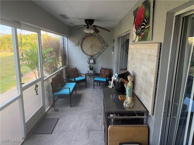 sunroom / solarium with visible vents, plenty of natural light, and a ceiling fan