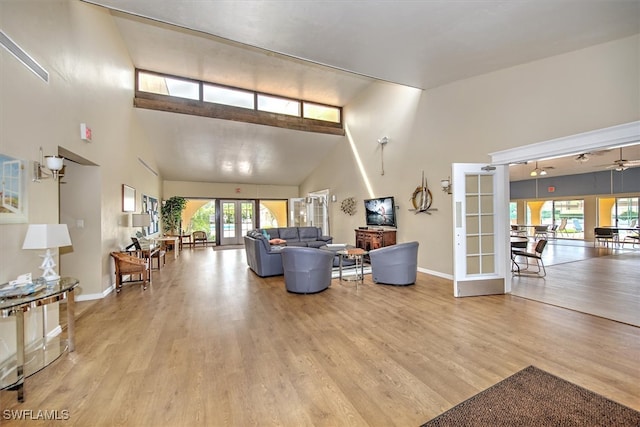 living room featuring ceiling fan, light hardwood / wood-style flooring, french doors, and high vaulted ceiling