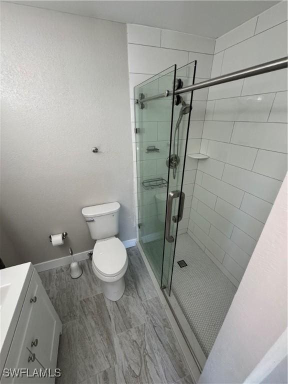 bathroom with vanity, toilet, and walk in shower