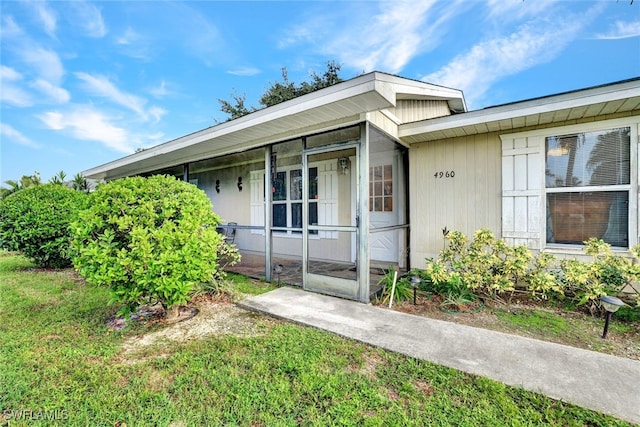 property entrance with a lawn