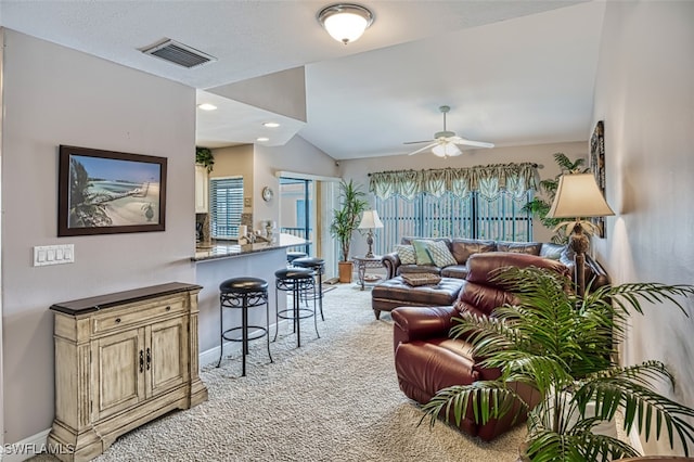 carpeted living room with ceiling fan and lofted ceiling