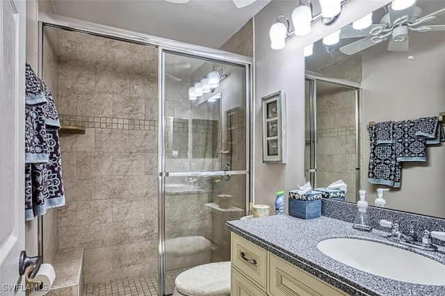 bathroom with ceiling fan, toilet, a shower with door, and vanity