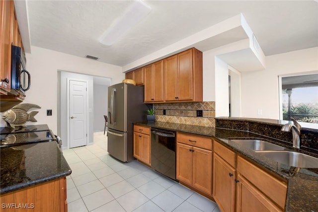 kitchen with sink, black appliances, tasteful backsplash, and dark stone counters