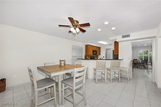 dining space with light tile patterned floors and ceiling fan