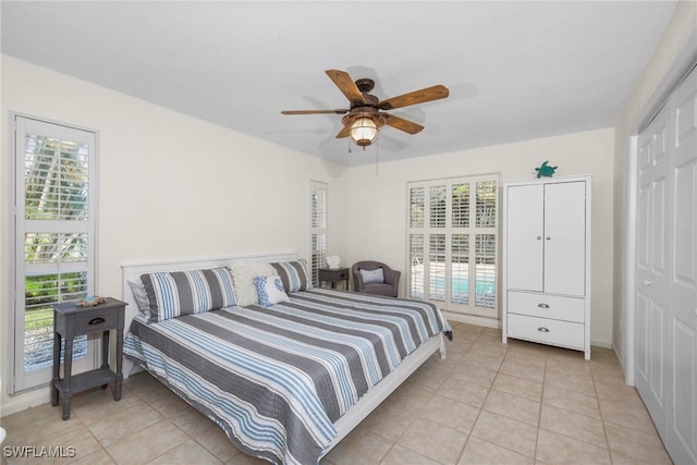 tiled bedroom featuring a closet, ceiling fan, and multiple windows