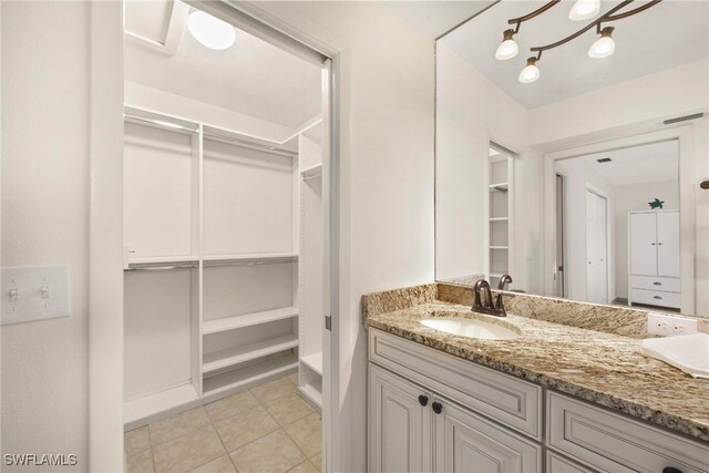 bathroom with vanity, a notable chandelier, and tile patterned flooring