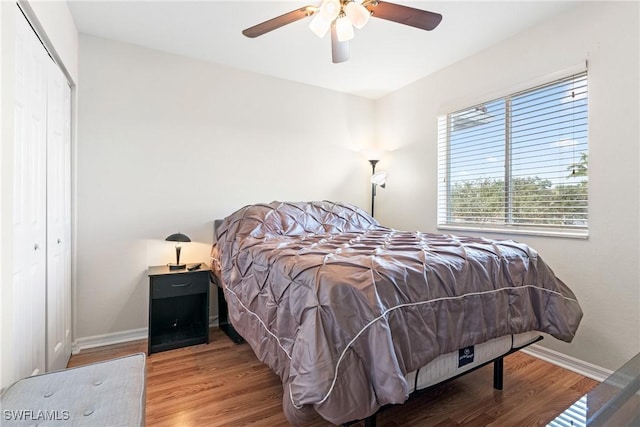 bedroom with baseboards, a closet, wood finished floors, and a ceiling fan