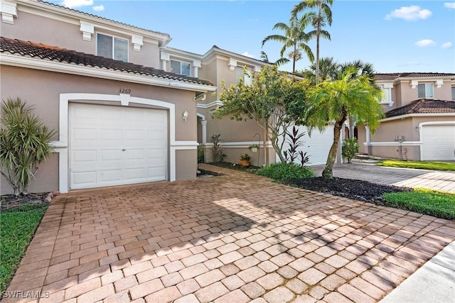 view of front of house featuring a tile roof, decorative driveway, and stucco siding